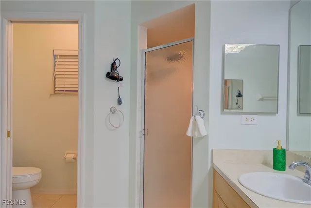 a bathroom with a granite countertop sink a toilet and shower