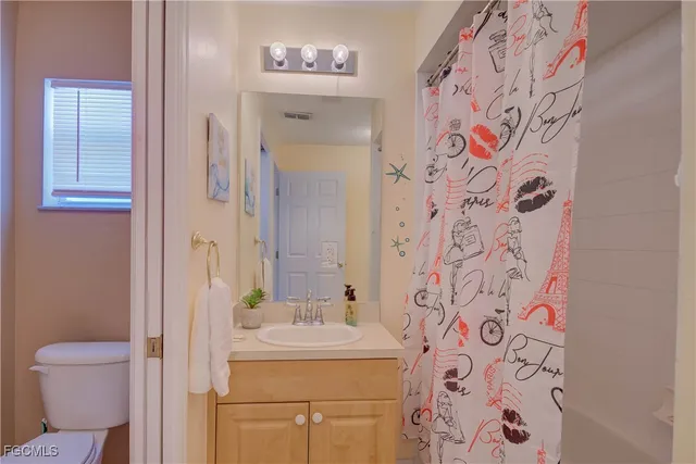 a bathroom with a sink and mirror with toilet