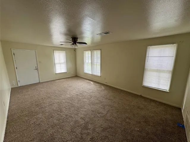 an empty room with windows and closet