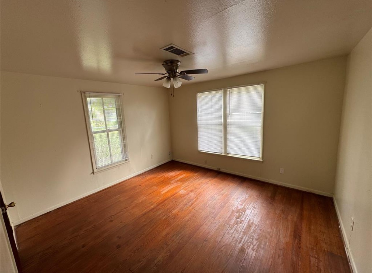 500 Tanner Avenue Cleveland, TX 77327 - Photo 5 of 9 an empty room with wooden floor chandelier fan and windows