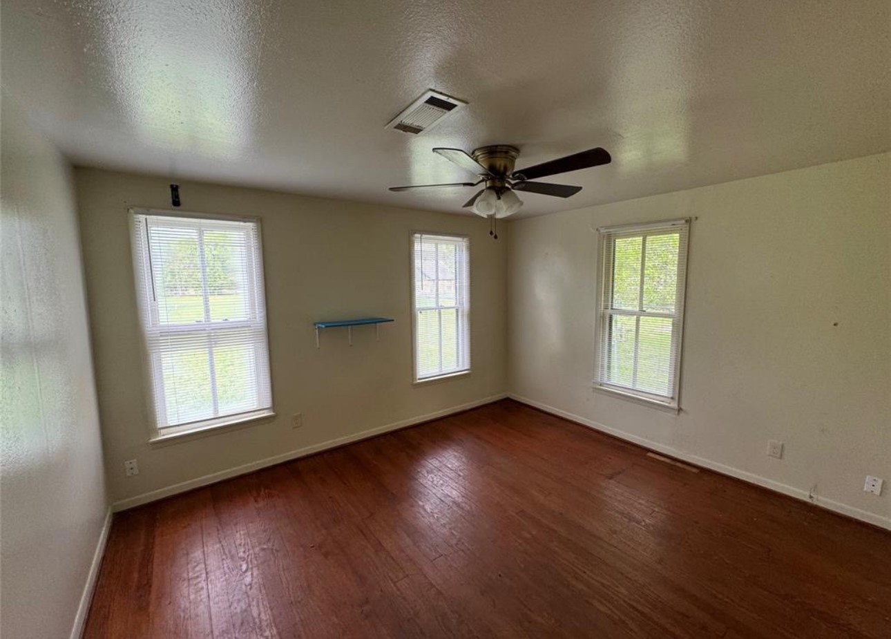 500 Tanner Avenue Cleveland, TX 77327 - Photo 6 of 9 a view of an empty room with wooden floor and a window