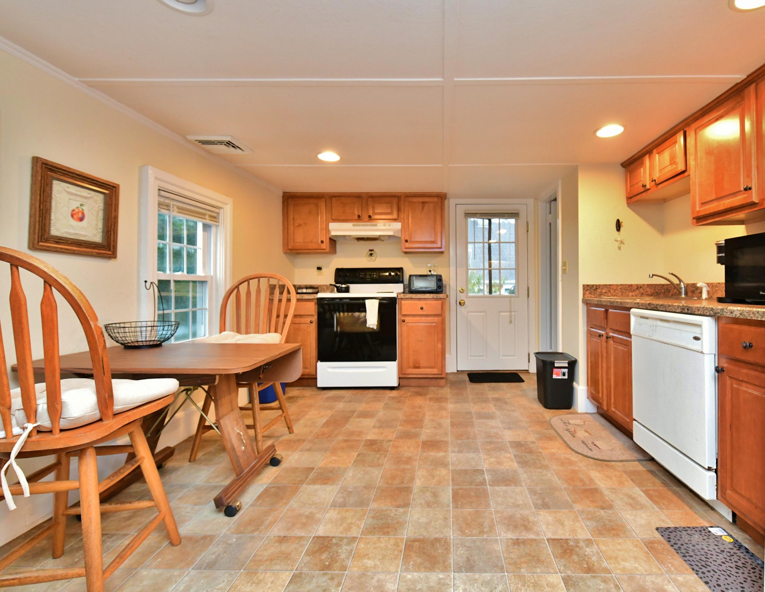 6 Bournedale Road, Unit 6B 2 Buzzards Bay, MA 02532 - Photo 4 of 36 a kitchen with stainless steel appliances kitchen island granite countertop a table and chairs in it