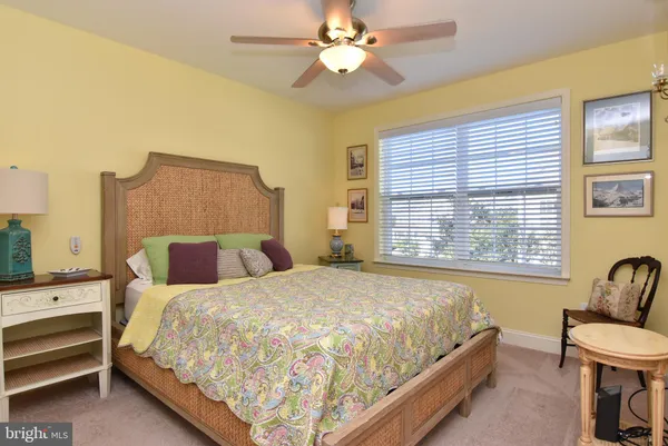 a large bed sitting in a bedroom next to a window and a chandelier
