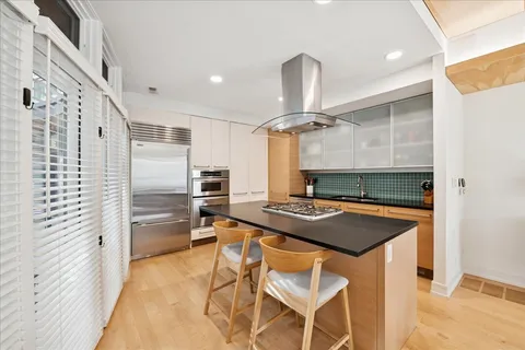 a kitchen with stainless steel appliances granite countertop a sink a stove and a refrigerator