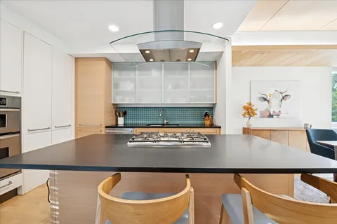 a kitchen with stainless steel appliances granite countertop a sink a stove and a refrigerator