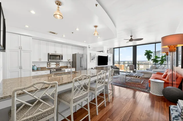 a view of a dining room with furniture a kitchen and chandelier