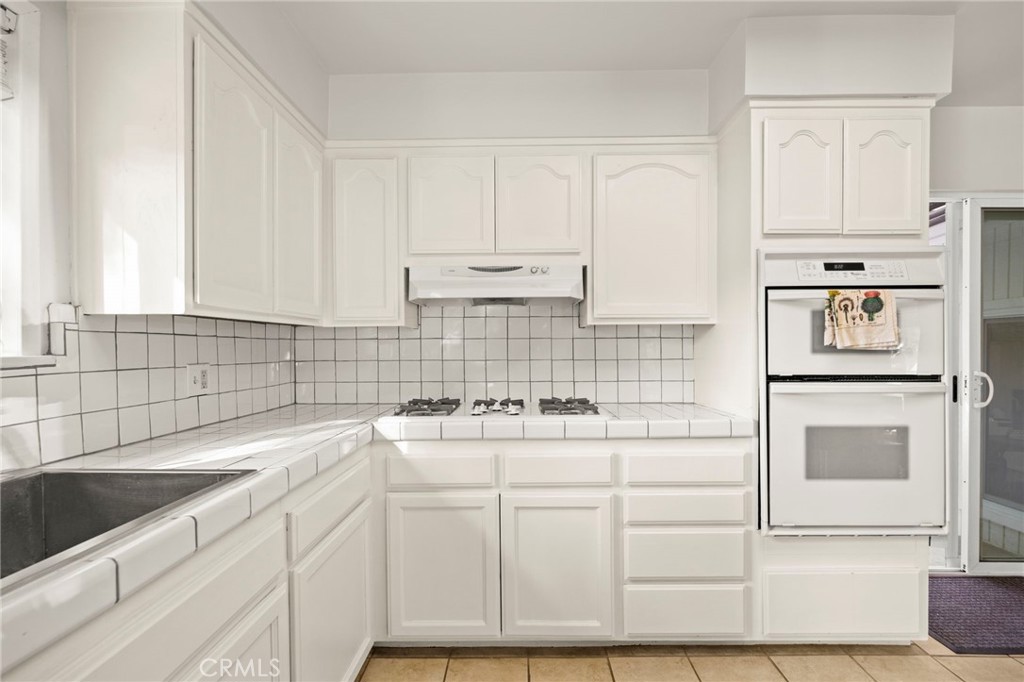 301 Park Road Ojai, CA 93023 - Photo 9 of 26 a kitchen with granite countertop white cabinets and white appliances