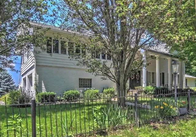 a front view of a house with a yard and potted plants