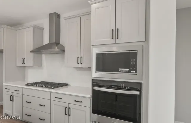 a kitchen with stainless steel appliances granite countertop a sink and stove top oven