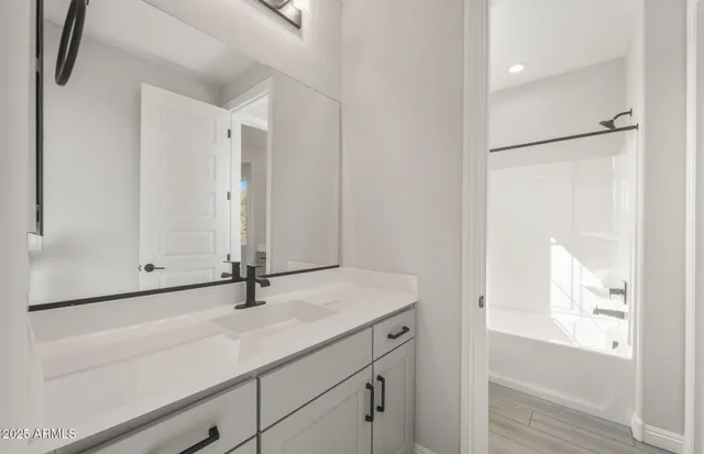 a bathroom with a sink a toilet and a large mirror