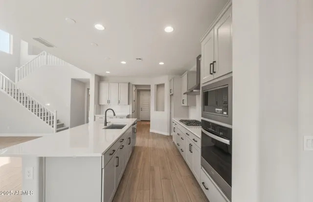 a large kitchen with a lot of counter space and wooden floor