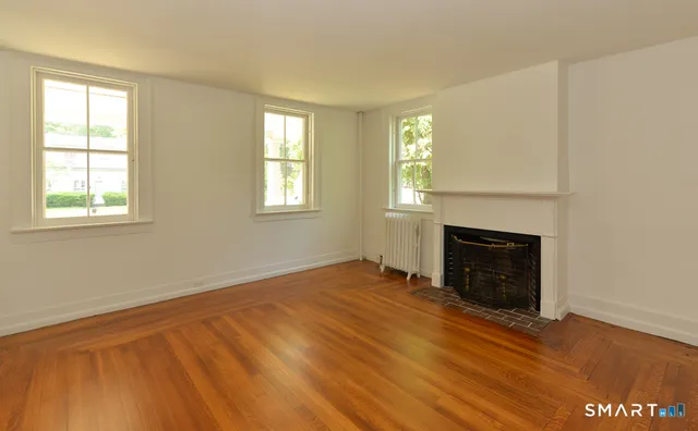an empty room with windows and fireplace