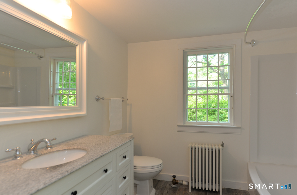 15 Hawkins Road Southbury, CT 06488 - Photo 7 of 26 a bathroom with a granite countertop toilet a sink a mirror and a window