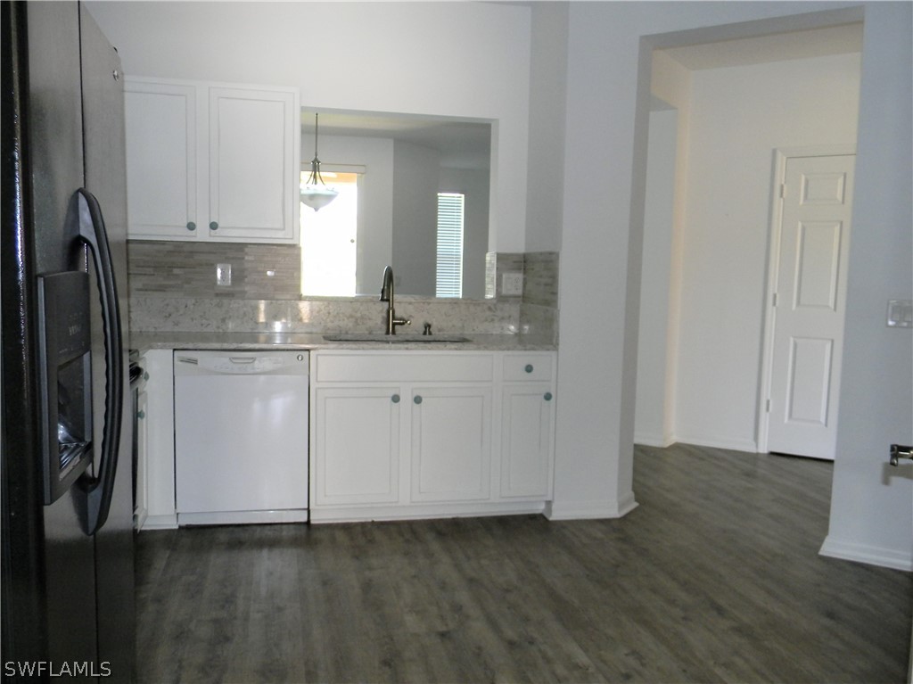 4109 Cherrybrook Loop Fort Myers, FL 33966 - Photo 5 of 32 a view of a kitchen with white cabinets and wooden floor