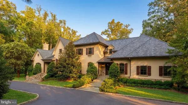 a front view of house with yard and trees around