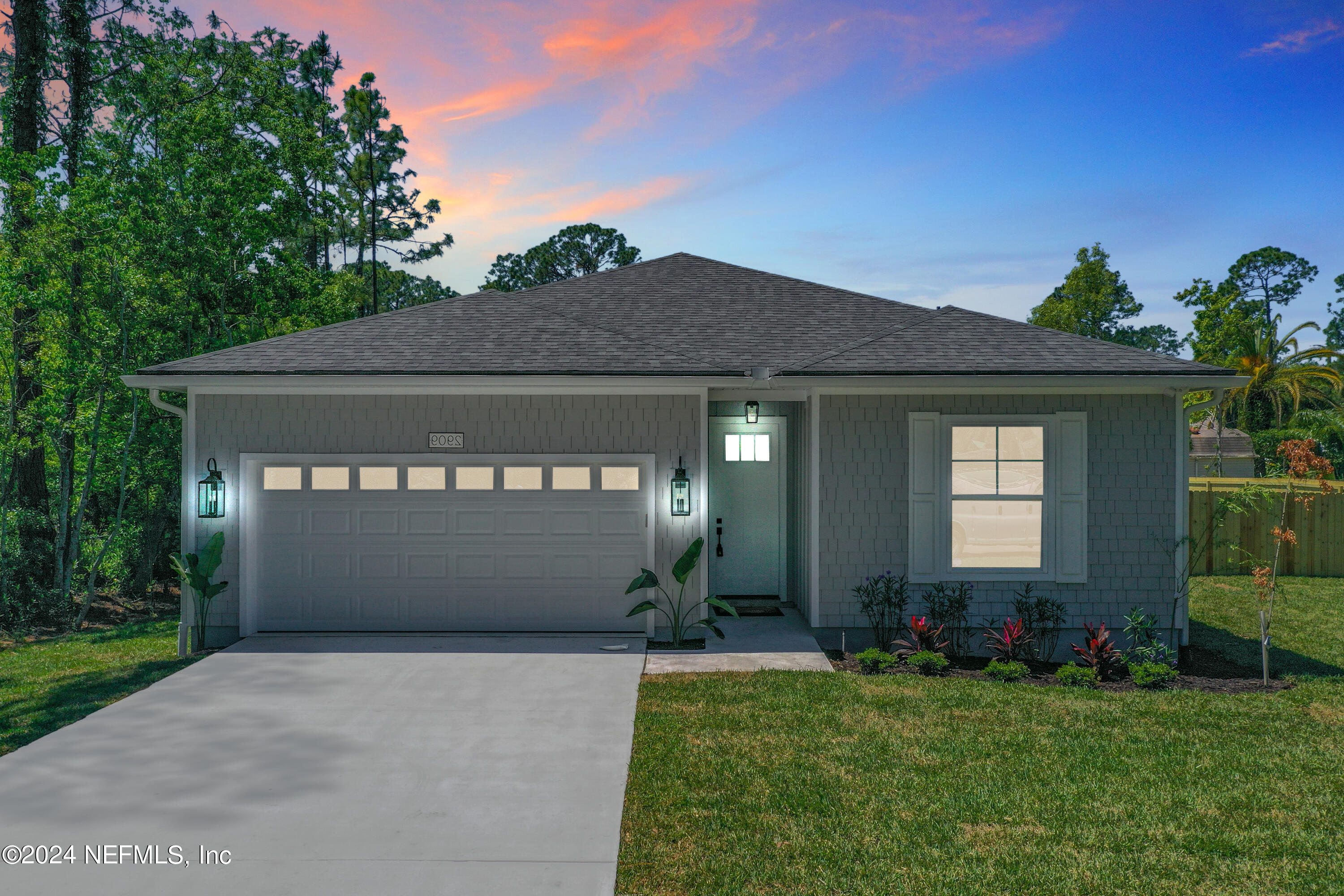 a front view of a house with a garden and garage