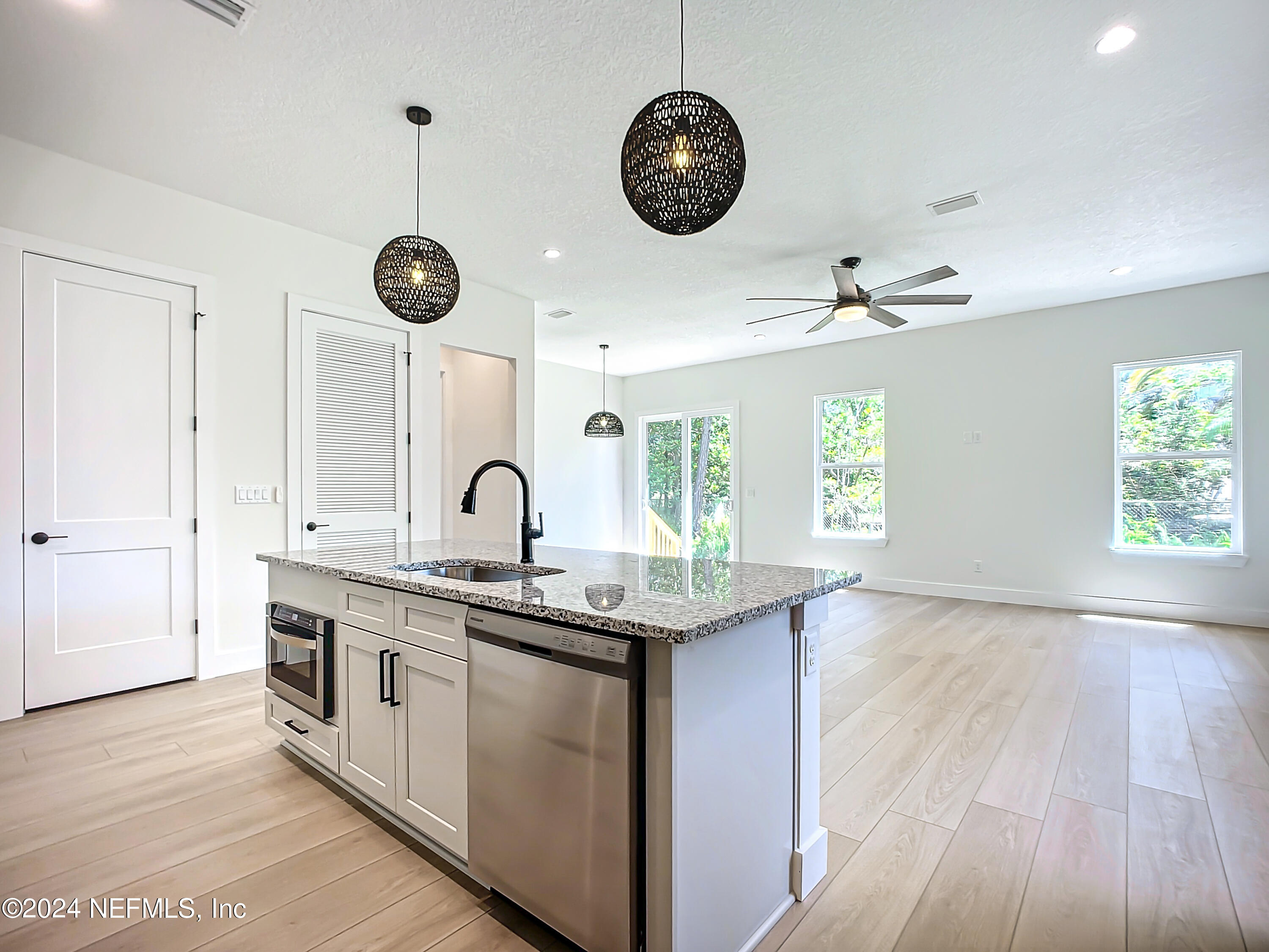 2903 Brougham Jacksonville, FL 32246 - Photo 13 of 40 a kitchen with stainless steel appliances granite countertop a stove oven a clock and white cabinets with wooden floor