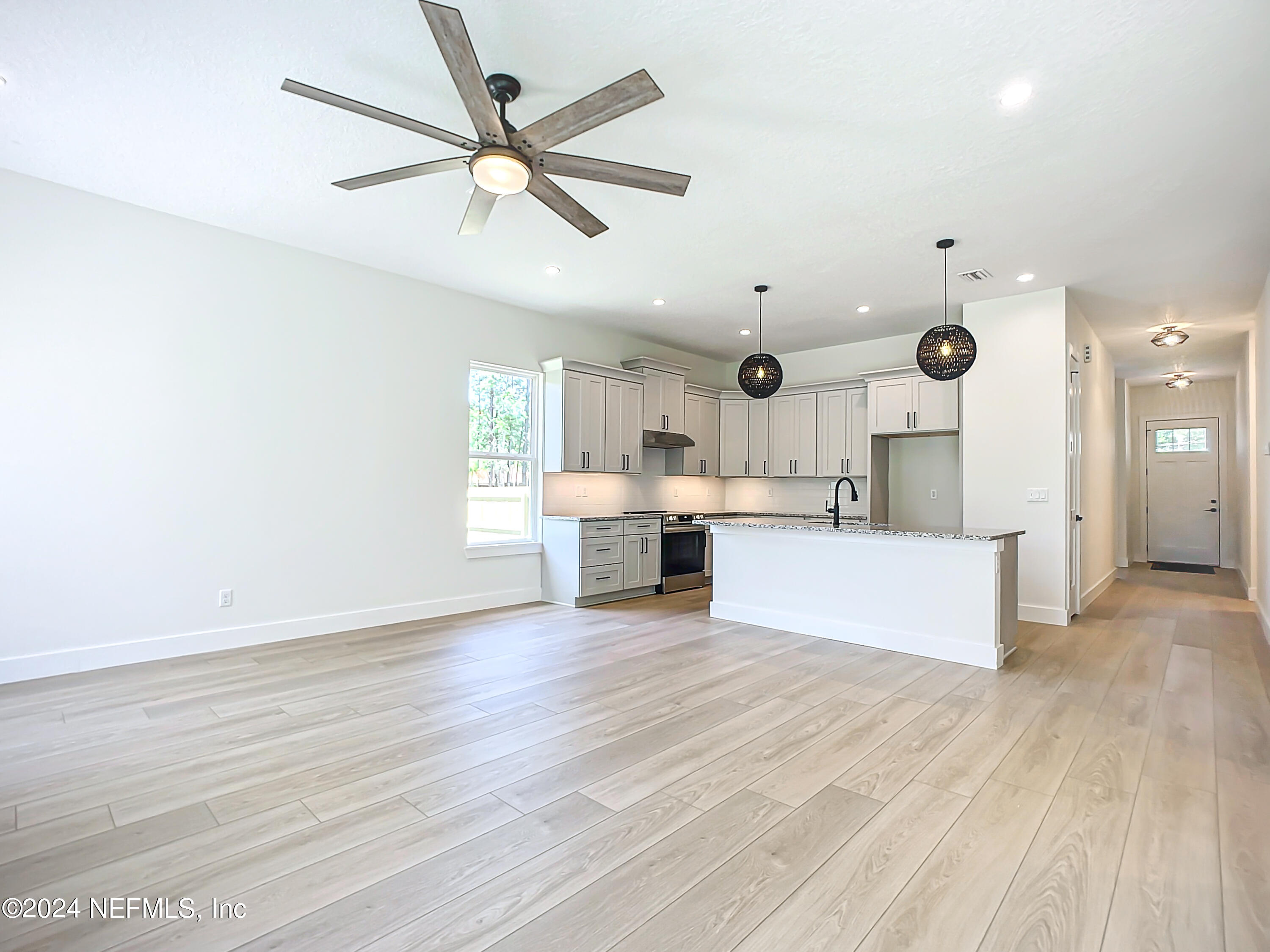 2903 Brougham Jacksonville, FL 32246 - Photo 8 of 40 a large kitchen with stainless steel appliances kitchen island a large counter top and a wooden floor
