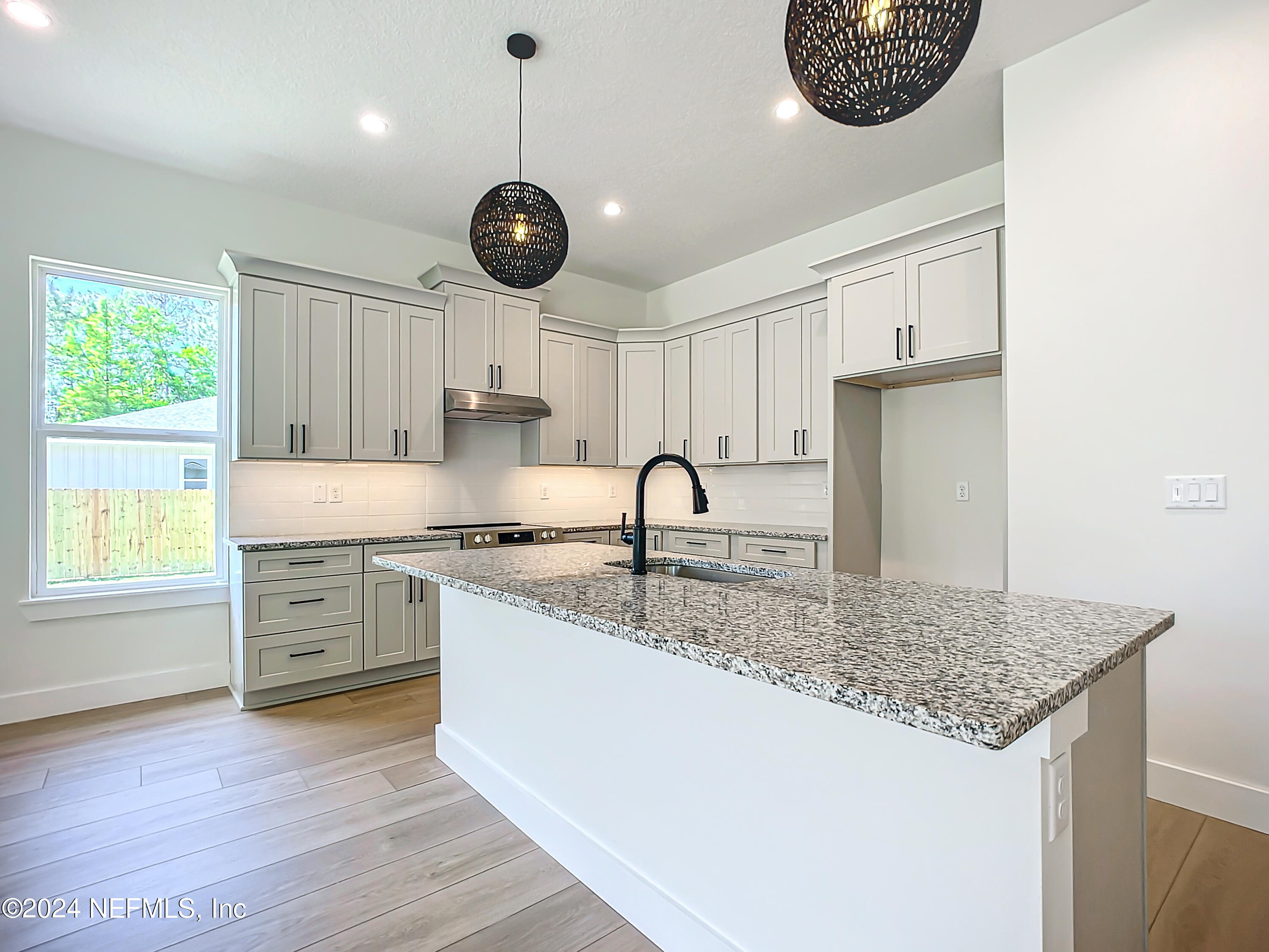 2903 Brougham Jacksonville, FL 32246 - Photo 10 of 40 a kitchen with stainless steel appliances granite countertop a kitchen island a stove a sink a dining table and chairs with wooden floor