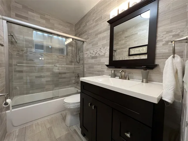 a bathroom with a sink shower and a toilet