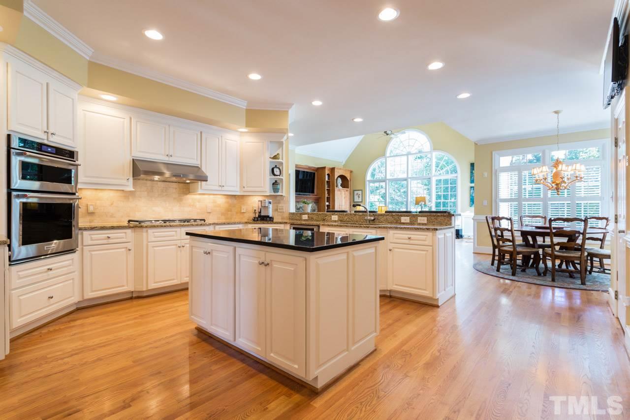 12528 Bayleaf Church Road Raleigh, NC 27614 - Photo 5 of 30 Tile Backsplash, Walk-in Pantry, Under-Cabinet Lighting, Large Island, Granite Counters, and Hardwood Floors