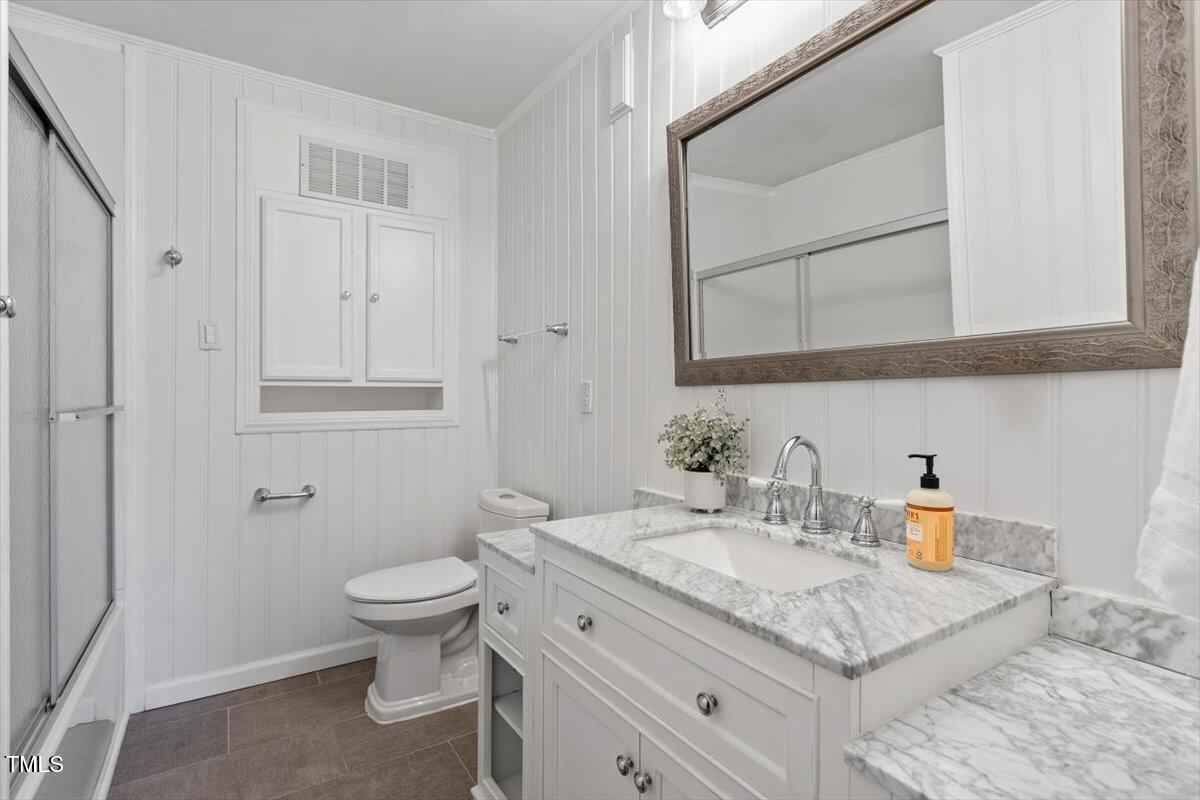 5707 Old Stage Road Raleigh, NC 27603 - Photo 15 of 50 a bathroom with a granite countertop sink a toilet and a mirror