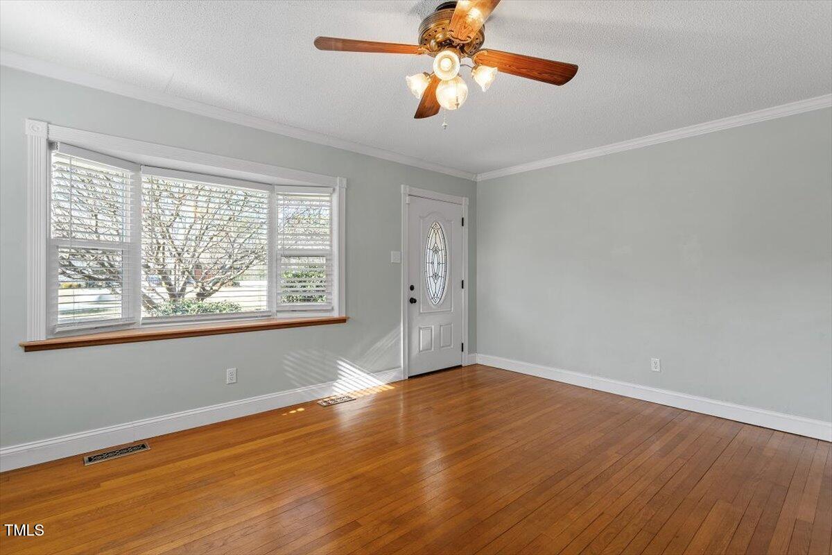 5707 Old Stage Road Raleigh, NC 27603 - Photo 24 of 50 a view of empty room with wooden floor and fan