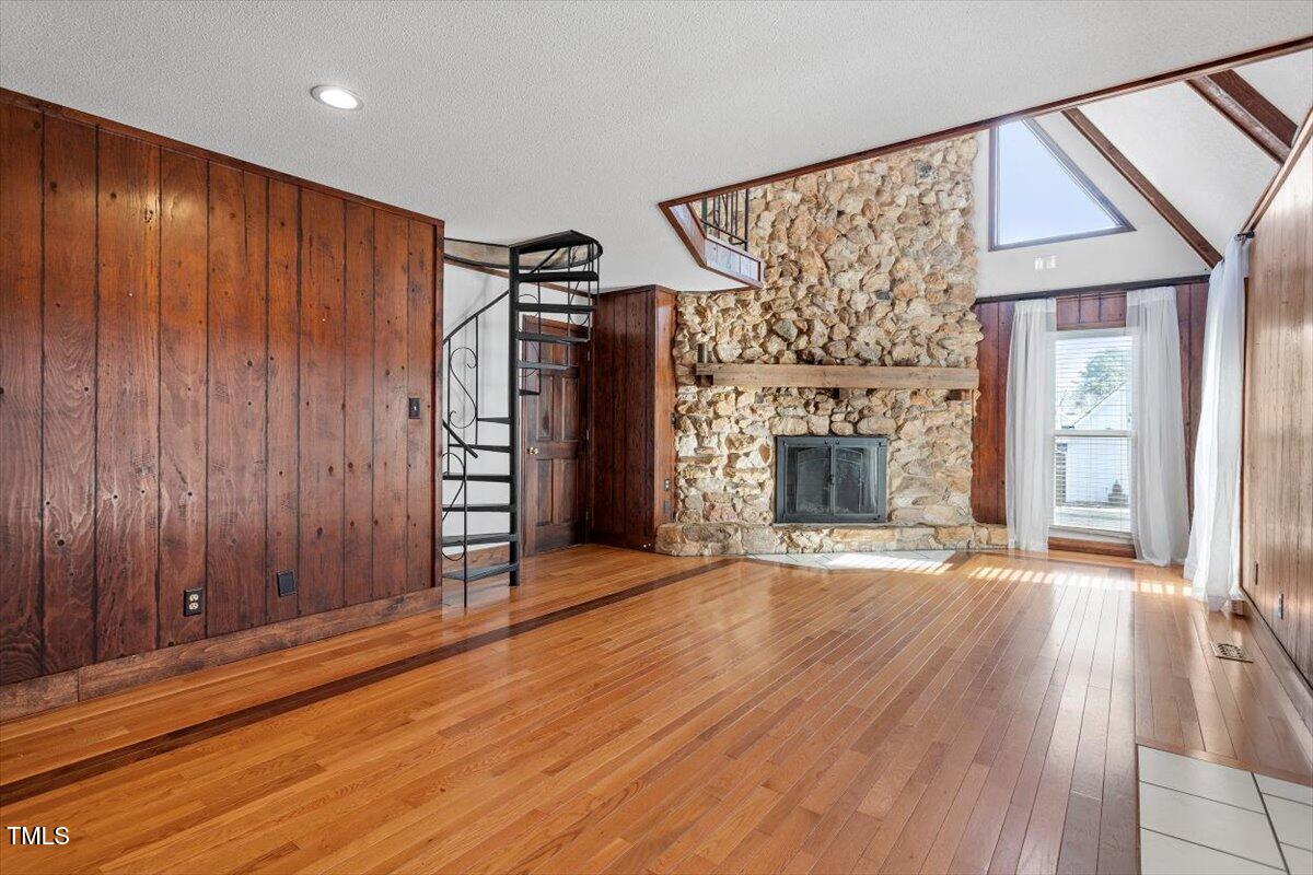 5707 Old Stage Road Raleigh, NC 27603 - Photo 26 of 50 an empty room with wooden floor fireplace and windows