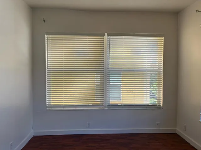 a view of a small space with wooden floor and a window
