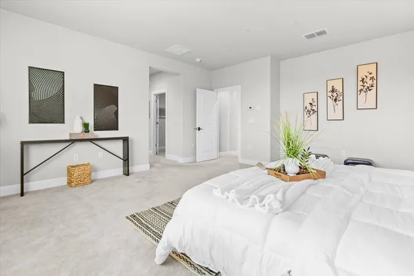 a bedroom with a bed and painting on the wall