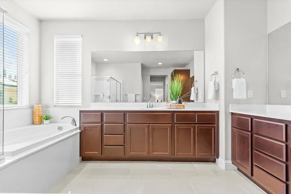 a spacious bathroom with a granite countertop tub sink and mirror