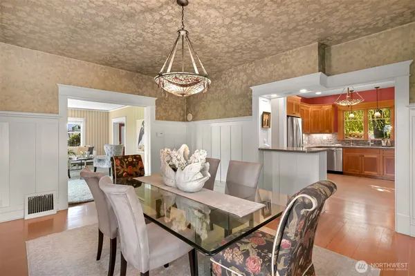 a view of a dining room and livingroom with furniture wooden floor a chandelier