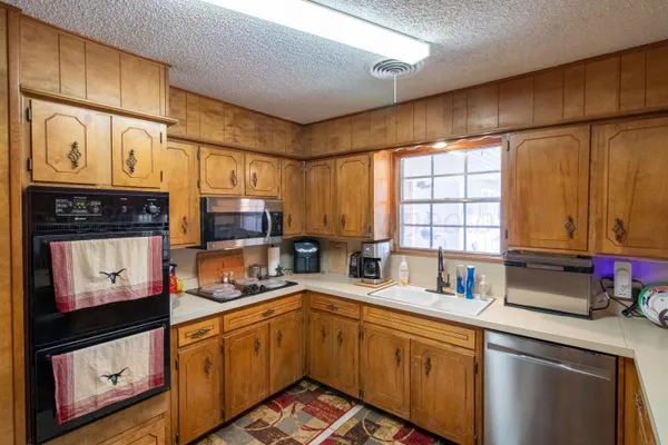 a kitchen with stainless steel appliances a sink cabinets and a window