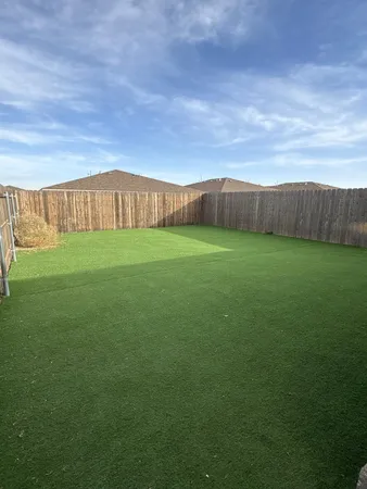 a view of a big room with a big yard and large trees