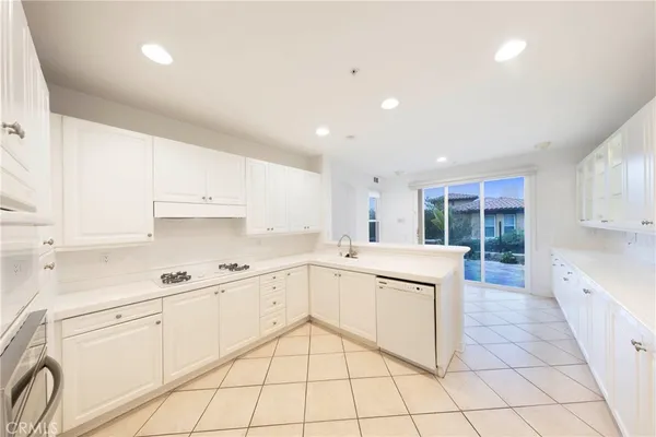 a kitchen with white cabinets appliances and a sink