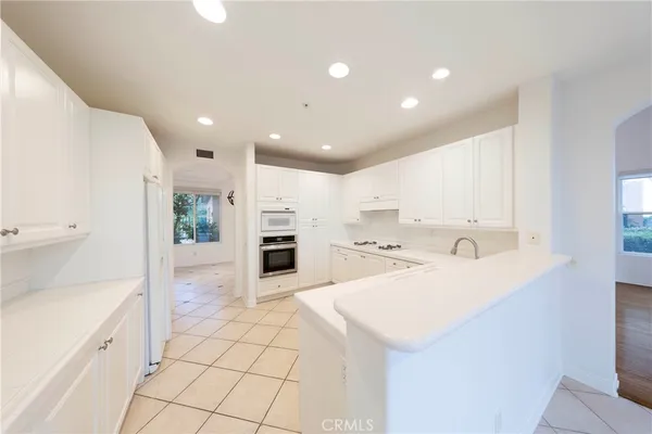 a kitchen with stainless steel appliances kitchen island granite countertop a refrigerator and a sink