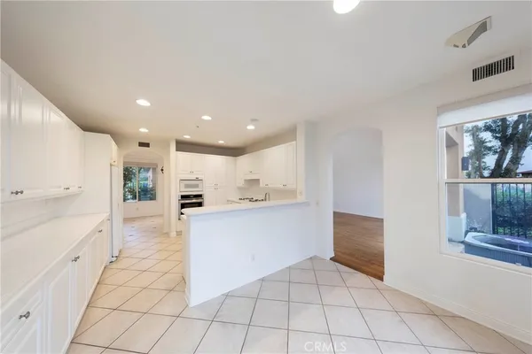 a kitchen with stainless steel appliances kitchen island granite countertop a refrigerator and a stove top oven