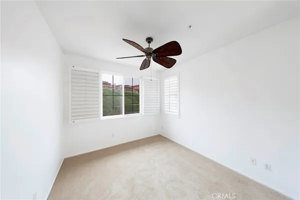 an empty room with a window and a fan
