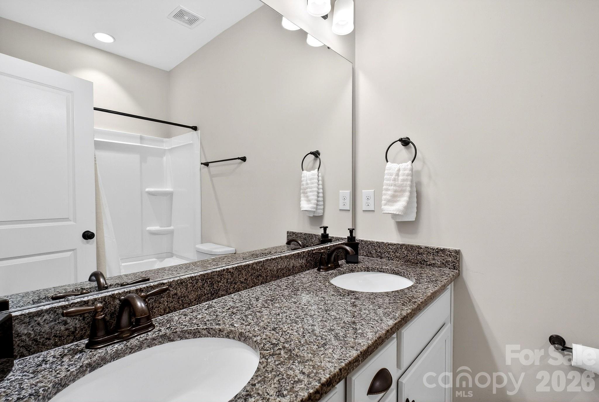 9092 Pitcairn Drive Fort Mill, SC 29708 - Photo 38 of 47 a bathroom with a granite countertop double sink and a mirror