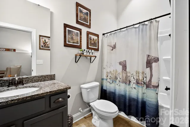 a bathroom with a granite countertop sink toilet and shower