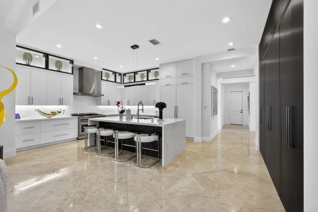 a dining room with furniture a large window and a chandelier