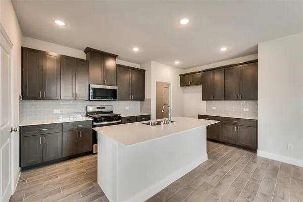 a kitchen with stainless steel appliances a sink stove and refrigerator