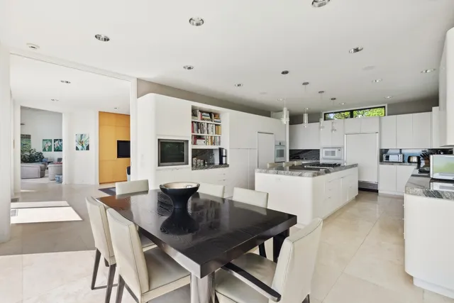 a kitchen with a dining table chairs and white cabinets