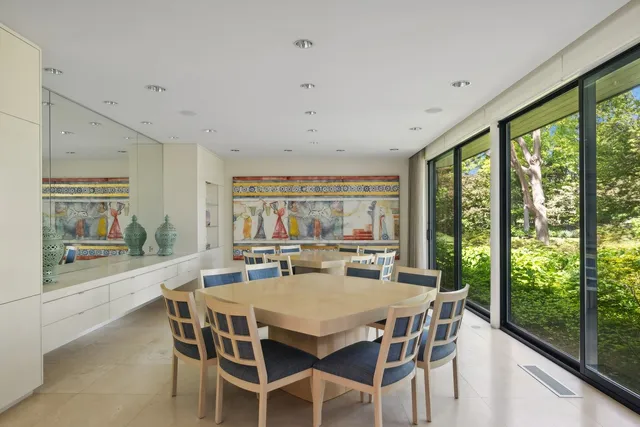a view of a dining room with furniture large windows and wooden floor