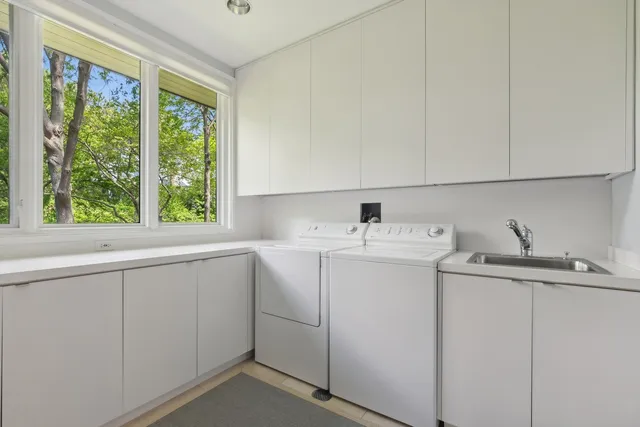 a utility room with cabinets washer and dryer