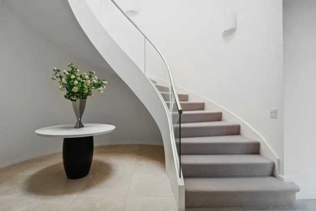 a view of staircase with white walls and a potted plant