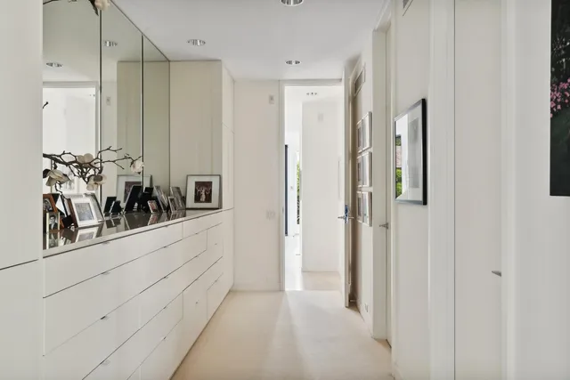 a view of a hallway with two mirror and furniture