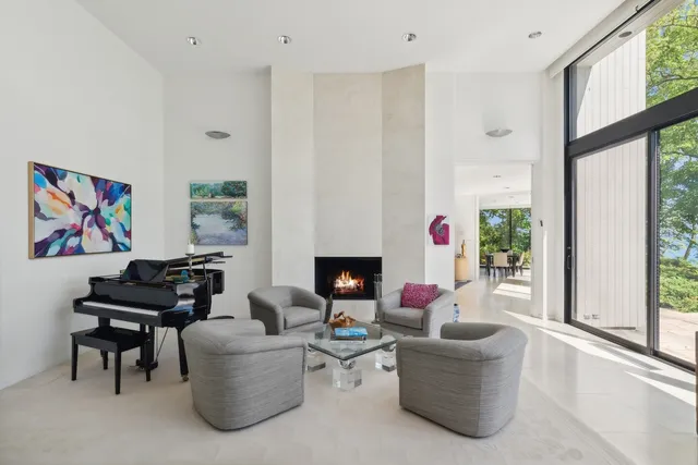 a living room with furniture a fireplace and a large window