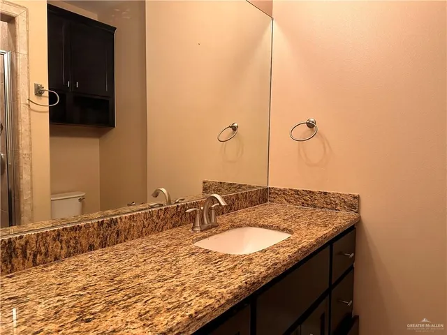 a bathroom with a granite countertop sink and a mirror