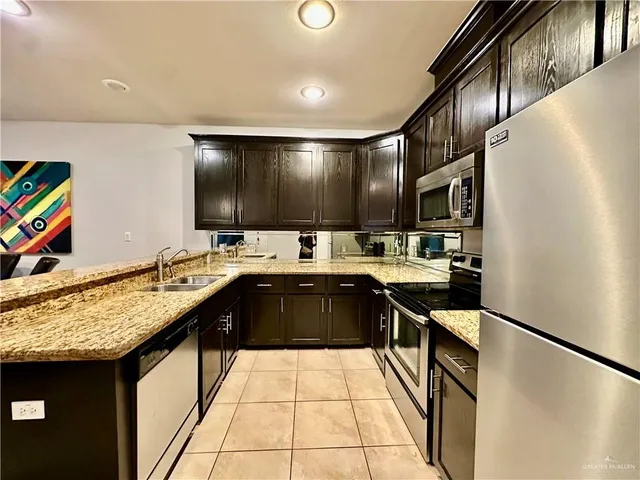 a kitchen with stainless steel appliances granite countertop a sink and cabinets